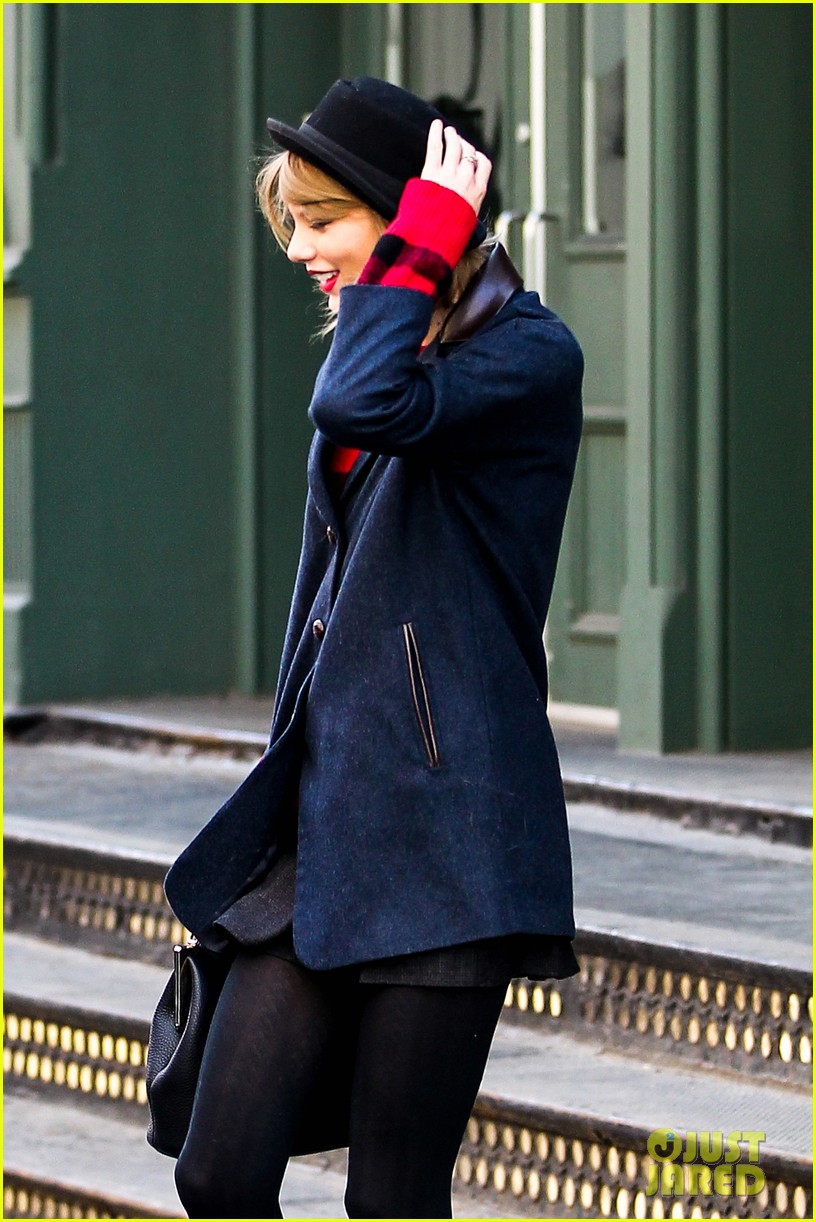 taylor swift holds onto her hat before it flies off her head 043078949