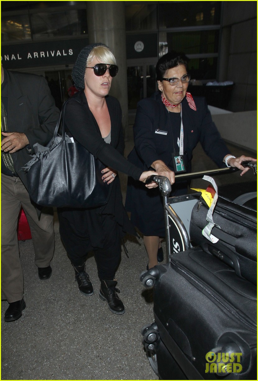 pink receives some help pushing her large cart of luggage 033153792