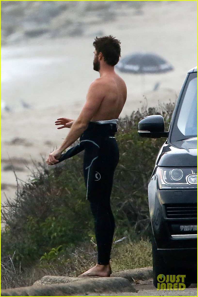 liam hemsworth bares his ripped abs while stripping out of wetsuit 183796108