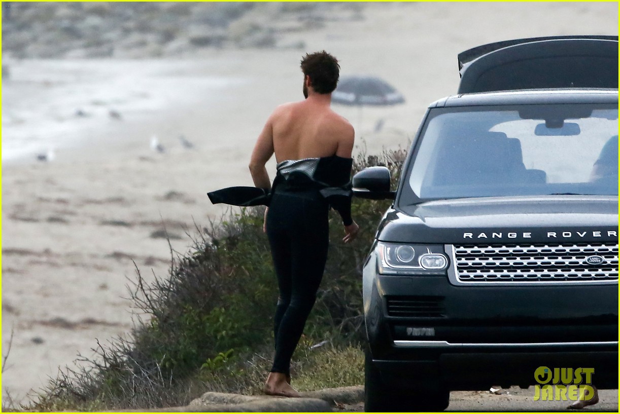 liam hemsworth bares his ripped abs while stripping out of wetsuit 193796109