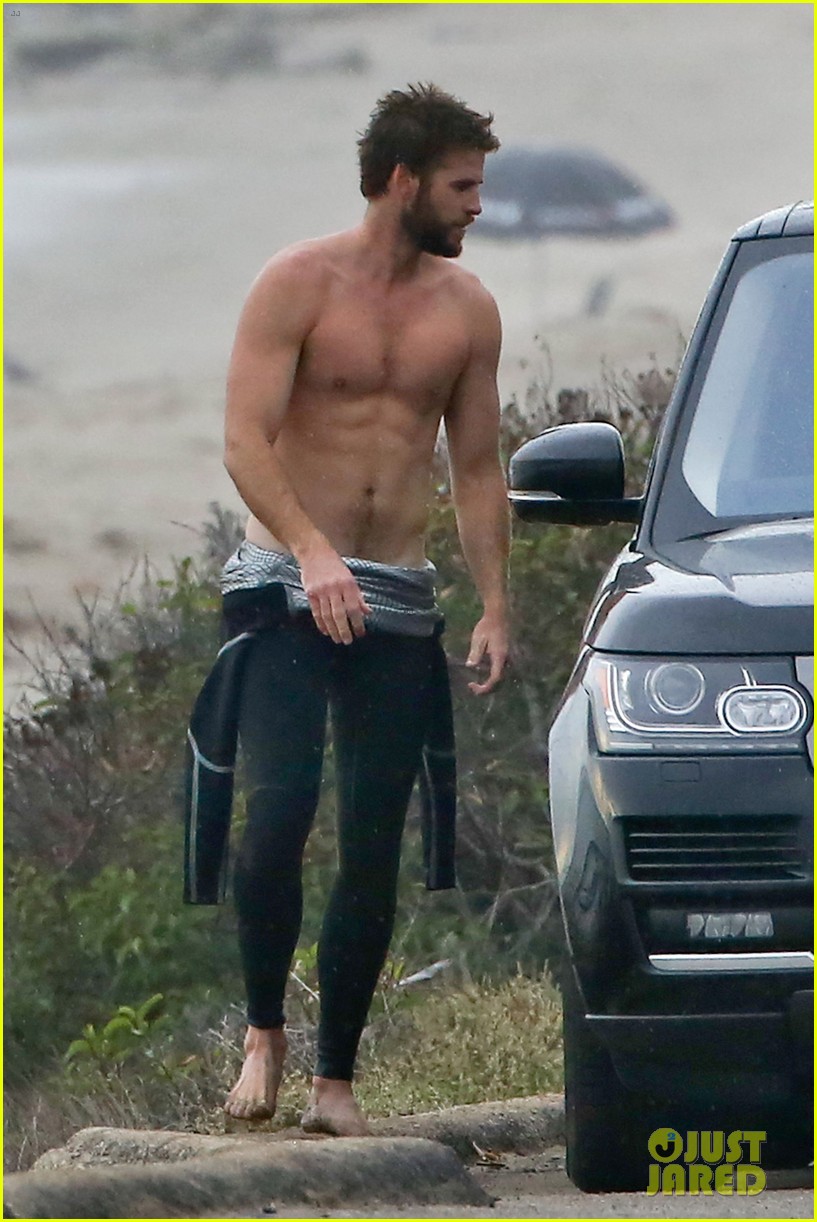 liam hemsworth bares his ripped abs while stripping out of wetsuit 253796115