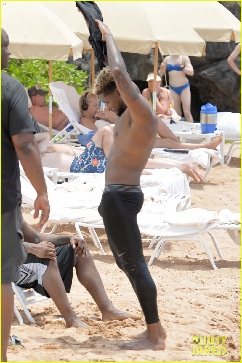 usher stays clothed while paddle boarding goes shirtless on beach 013897173