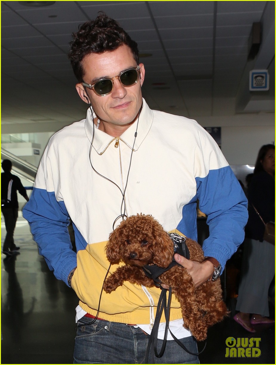 orlando bloom carries his cute dog through the airport 02