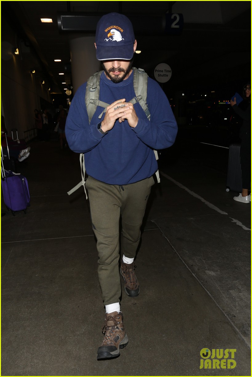 shia labeouf keeps a low profile for his flight into lax 03